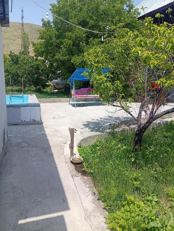 a park with a tree and a playground at Дом in Shorzha