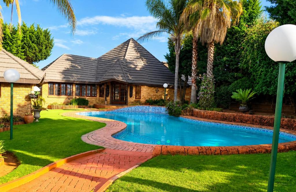 a house with a swimming pool in the yard at EastClaire Guesthouse in Krugersdorp