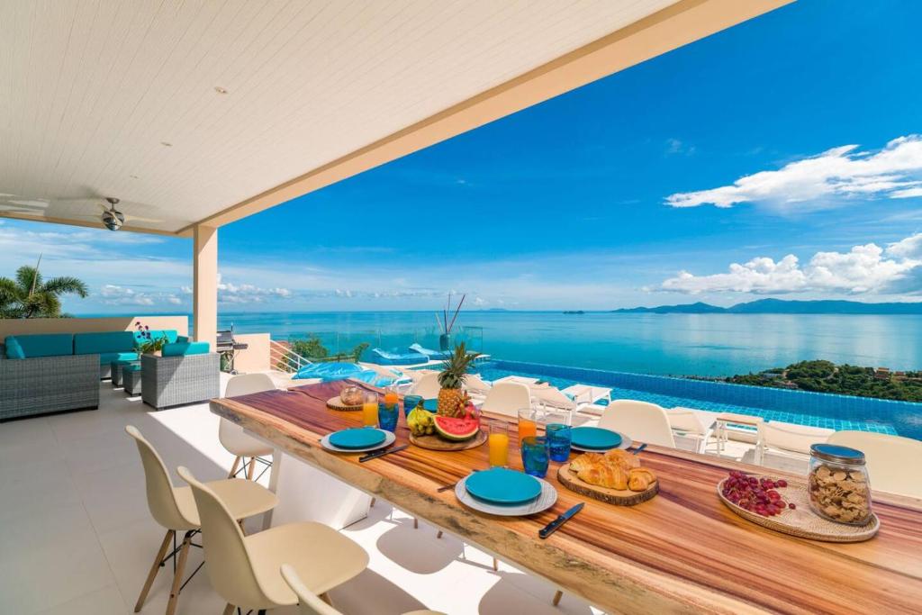 a dining table on the balcony with a view of the ocean at The View in Ban Tai