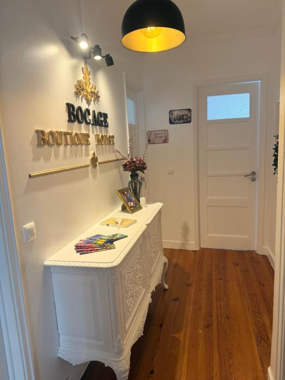 a room with a white table with a sign on the wall at Bogage Boutique House in Setúbal