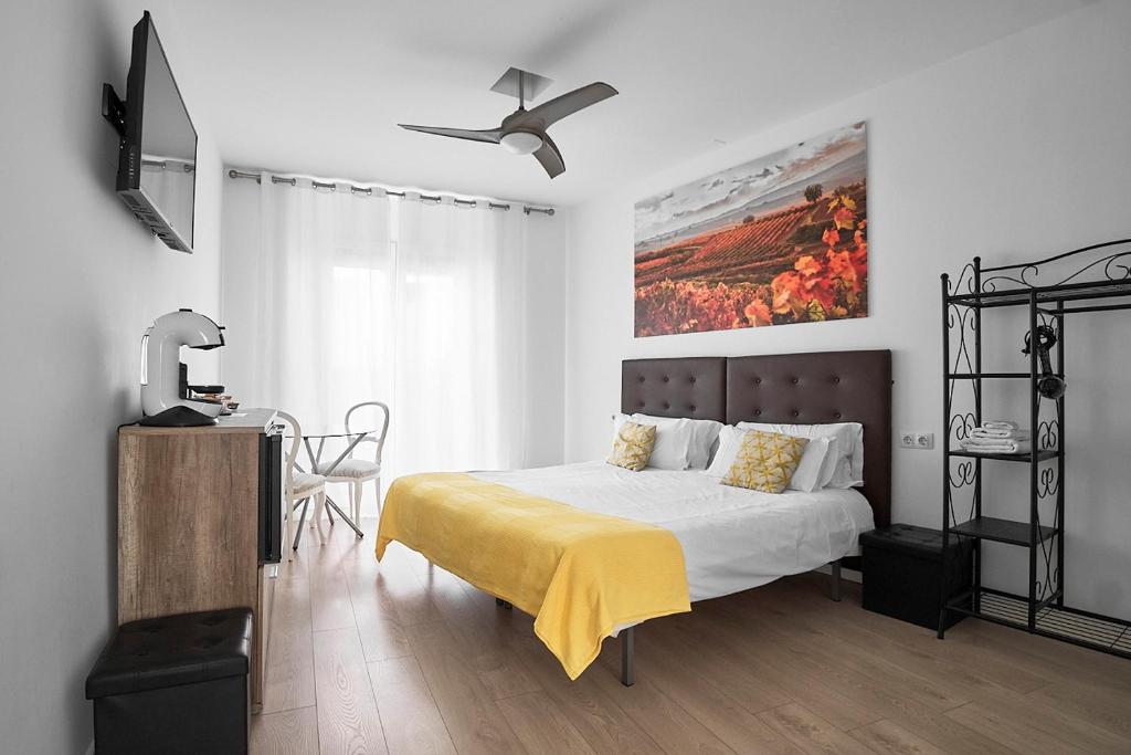 a bedroom with a bed with a yellow blanket on it at Hostal Puente de Hierro in Logroño