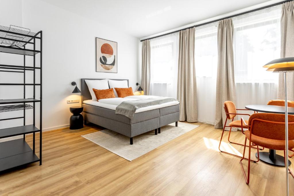 a bedroom with a bed and a table and chairs at Global Living Chemnitz Rosenhof in Chemnitz