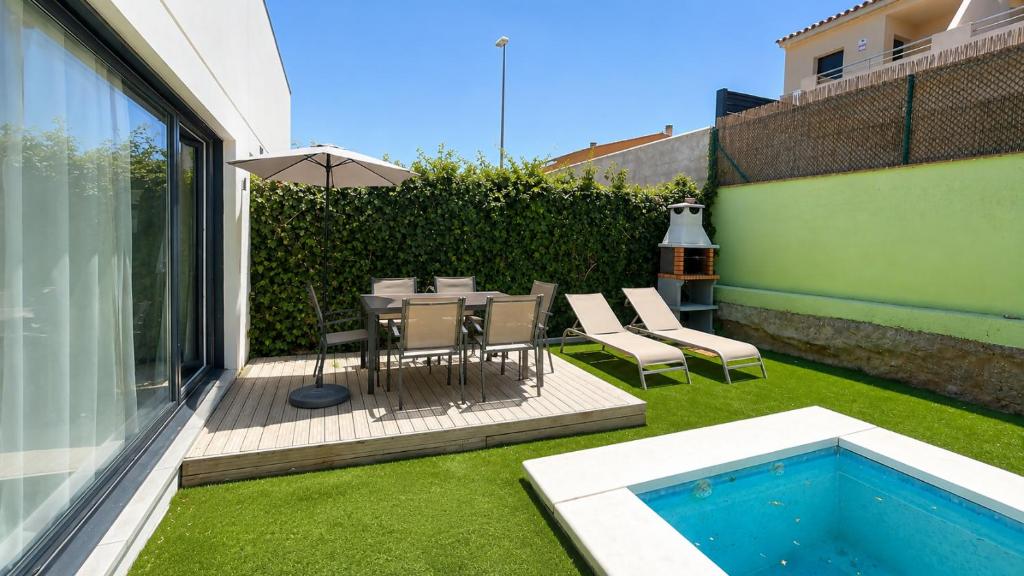 a patio with a table and chairs and a swimming pool at Jouvacations Villa Sol La Selva in Vilafant
