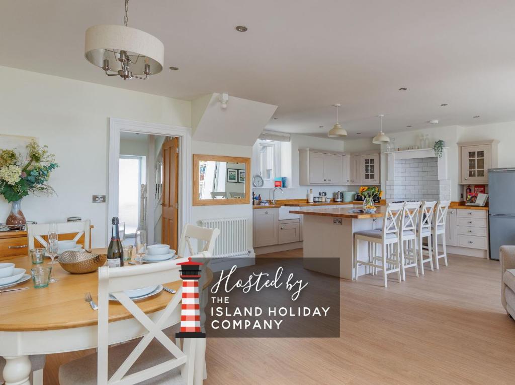 a kitchen and living room with a table and chairs at 5 Old School Mews Shanklin in Shanklin