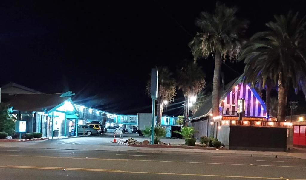 a city street at night with a gas station at Tiki Lodge Hotel Modesto in Modesto