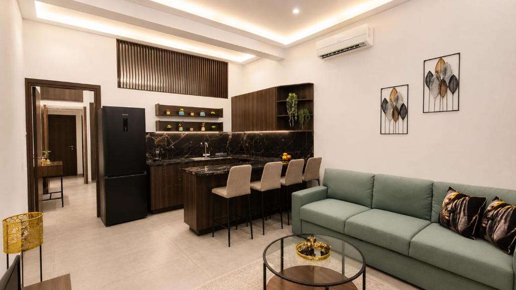 a living room with a green couch and a kitchen at Allure Suites in Larnaca