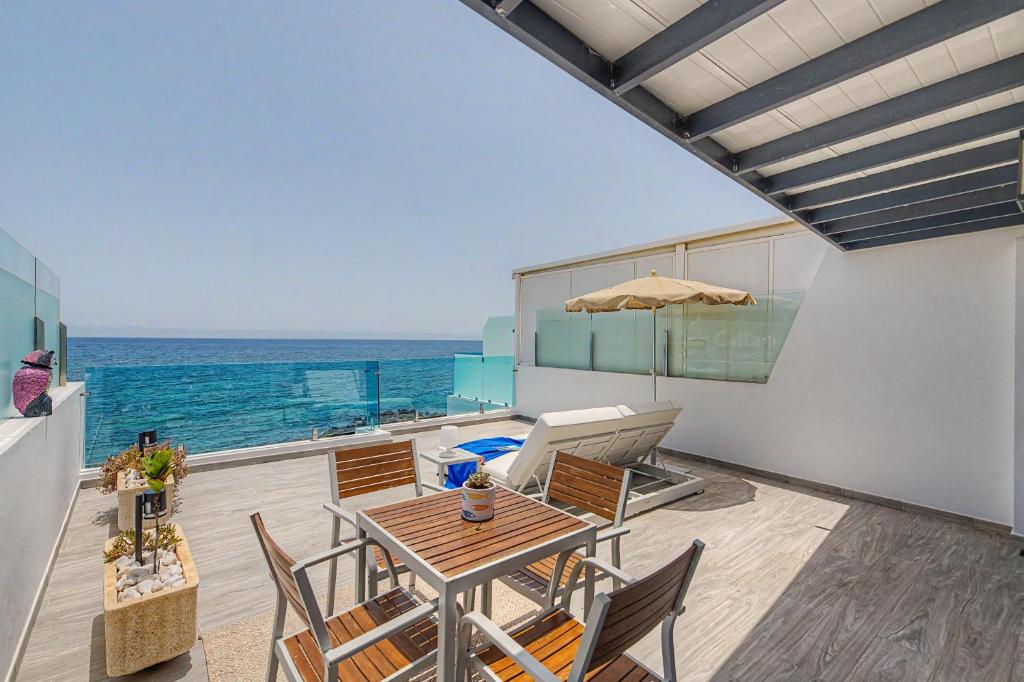 a patio with a table and chairs and the ocean at Callao Beach 8 in Arrieta