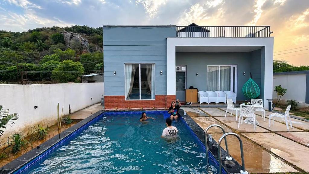 a family in a swimming pool in a house at 4j Aravalli Farms in Dhauj
