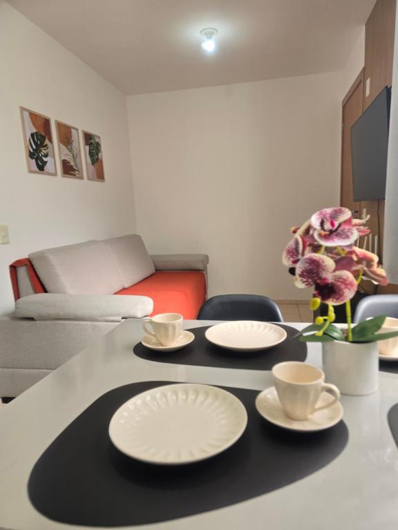 a living room with a table with plates on it at Bem-vindo ao seu refúgio em Palhoça in Palhoça