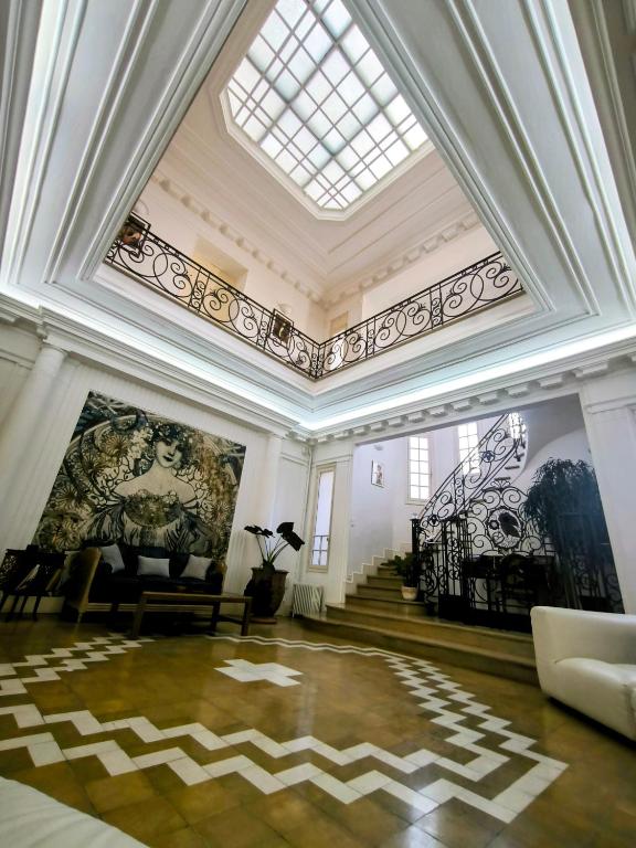 a large room with a ceiling with paintings on the walls at Villa Meyer Demeure Remarquable chambre d'hôtes,Art Déco,standing in Béziers