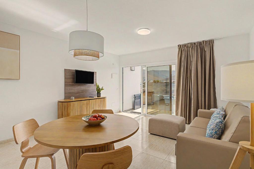 a living room with a table and a couch at Callao Beach 5 in Arrieta