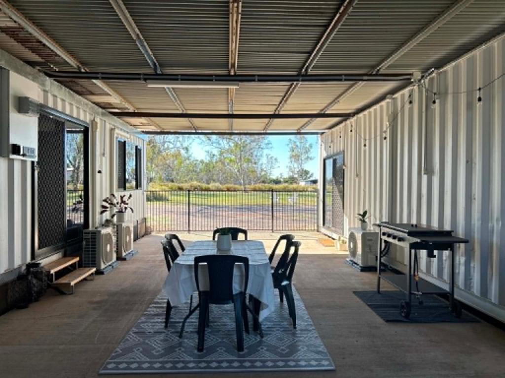 a covered patio with a table and a piano at Outback Getaway Home in Mount Isa