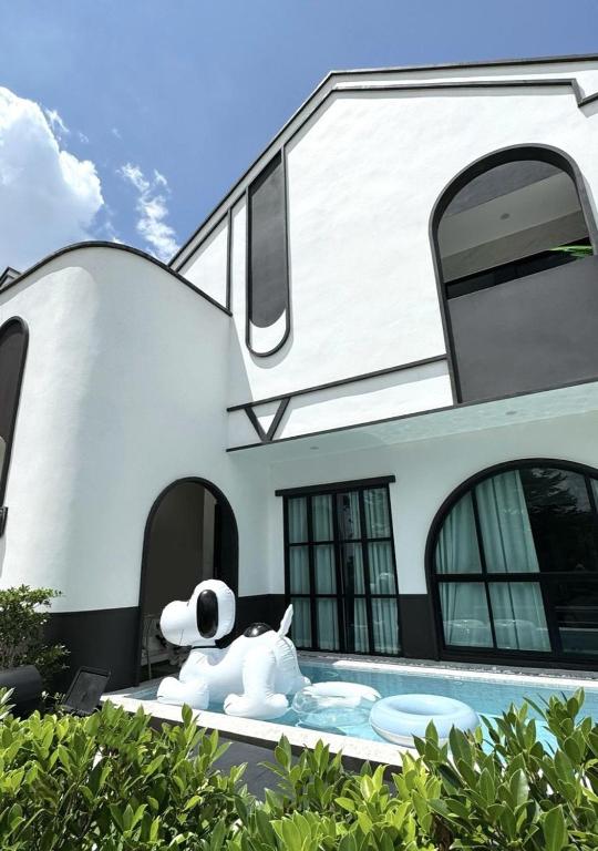 a dog laying in front of a house at V Villa Khaoyai in Ban Nong Ka Cha
