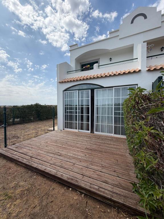 a house with a wooden deck in front of it at Sunset Ria in Tavira