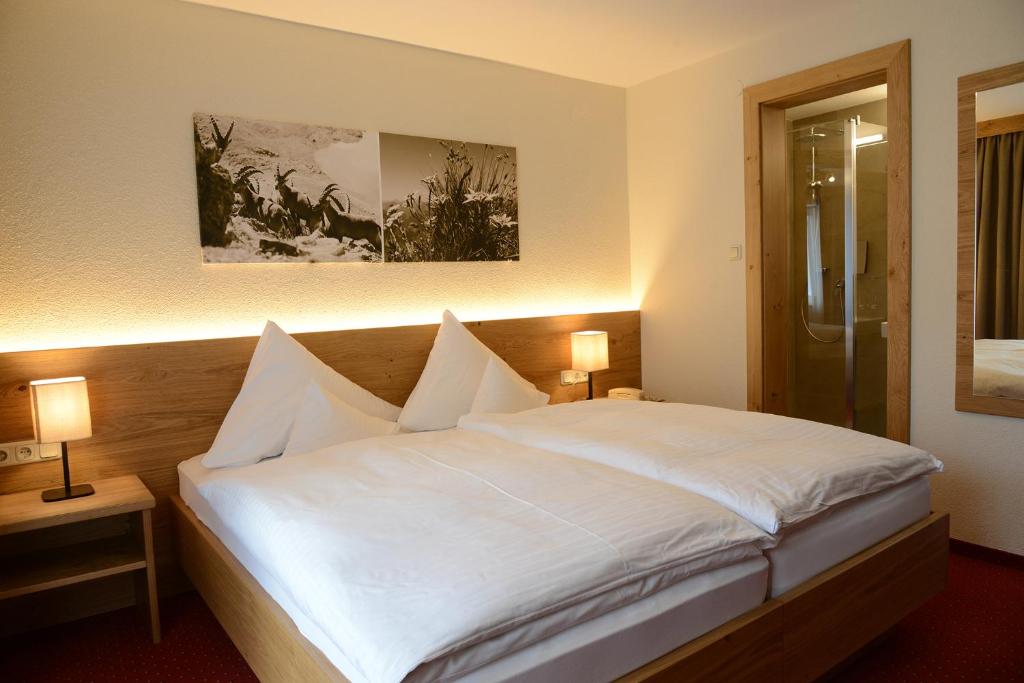 Postel nebo postele na pokoji v ubytování "Quality Hosts Arlberg" Hotel Garni Mössmer