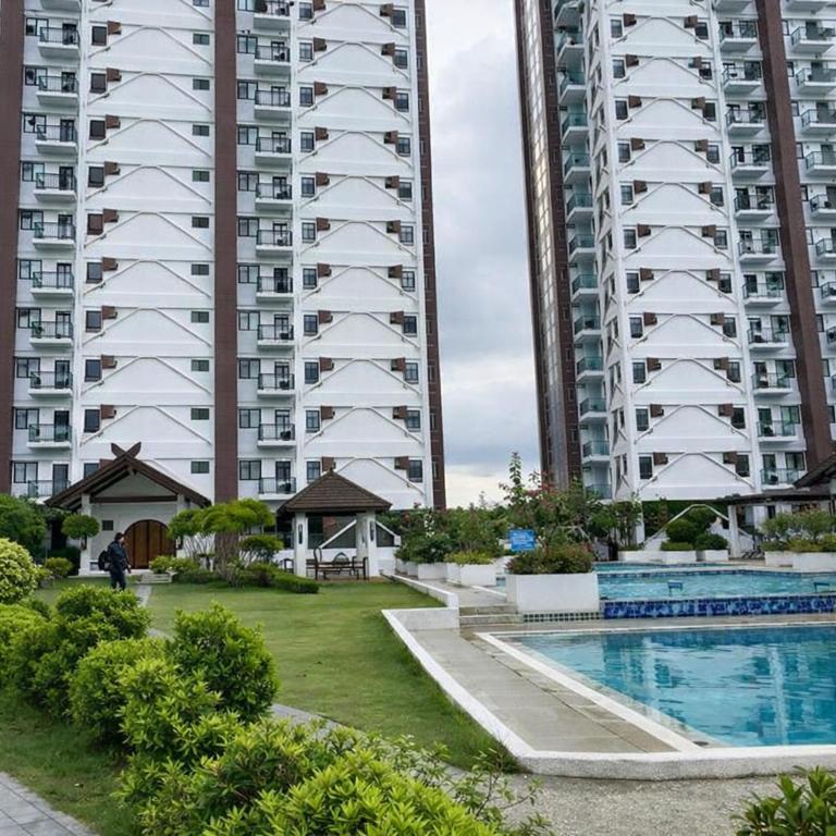 a large apartment building with a pool in front of it at Mely's Condotel Mactan in Mactan Island