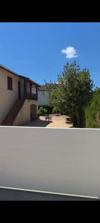 a view of a building with a tree and a street at Paradis Oyonnax in Bellignat