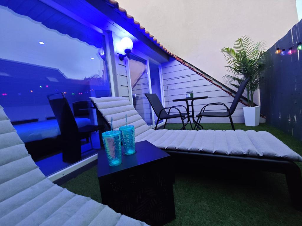 a patio with a couch and a table on a balcony at Chambre confortable 2P avec Terasse in Ostend