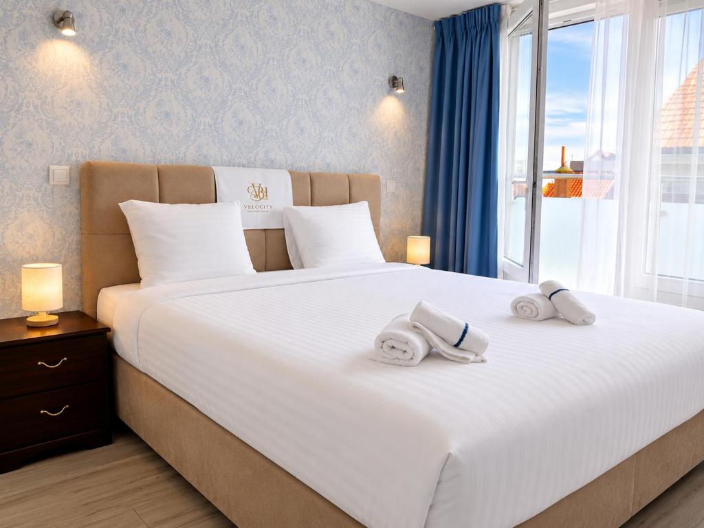 a bedroom with a large white bed with towels on it at Velocity boutique hotel in Zandvoort
