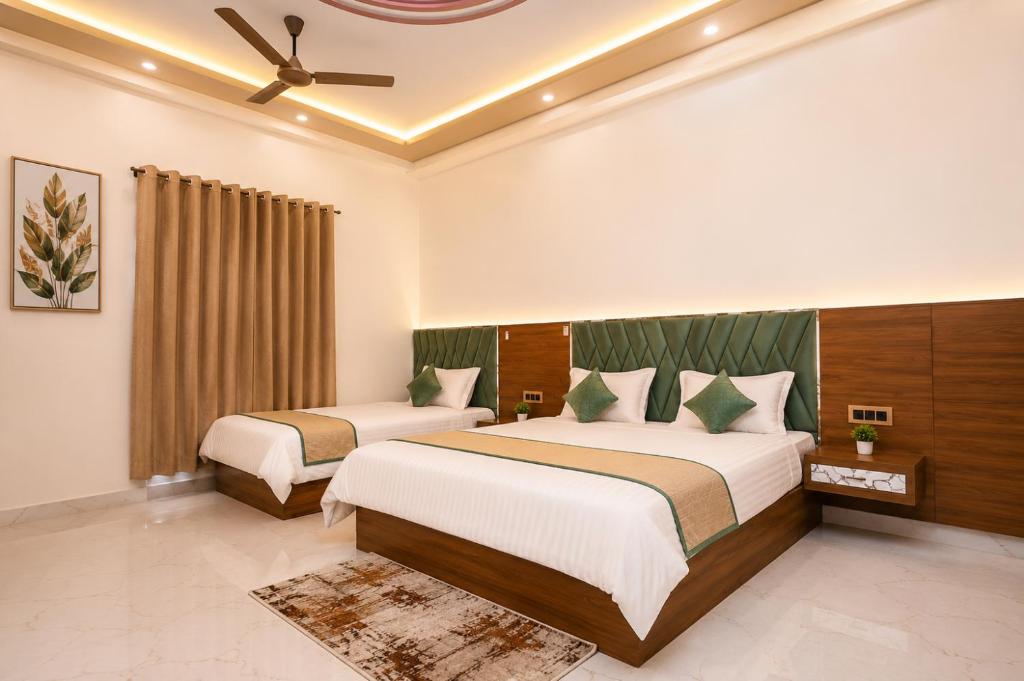 a bedroom with two beds and a ceiling fan at Hotel Ramkesarrai in Ayodhya