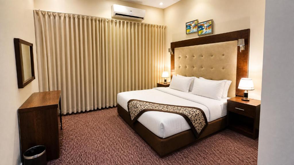 a hotel room with a large bed with white sheets at Dome El Nozha in Riyadh