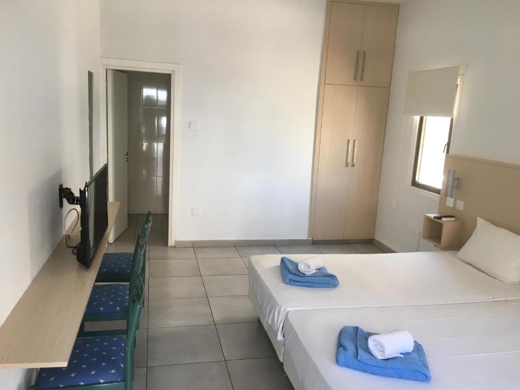 a room with two beds with towels on them at Mandali Court in Ayia Napa