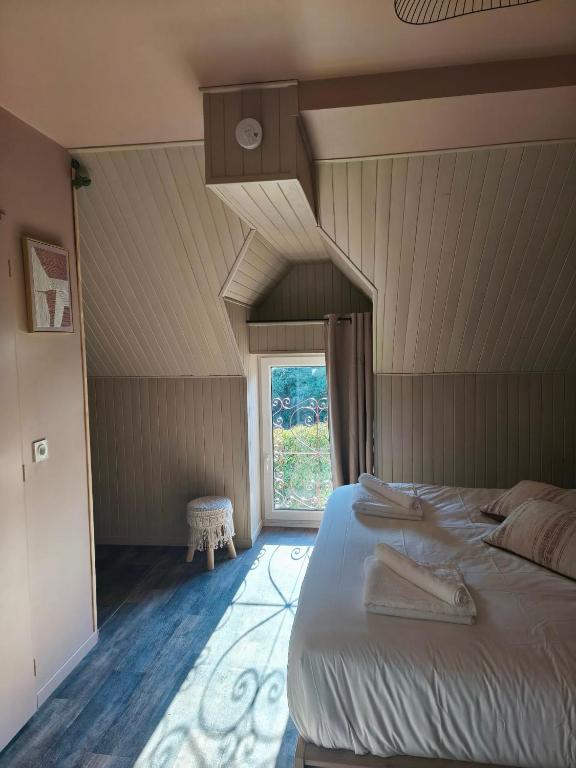 a bedroom with a large bed and a window at Chambre d'hôte in Maligny