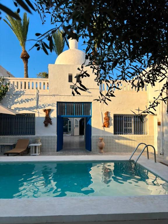 a house with a swimming pool in front of a building at CoZi at Dar Faiza in Houmt Souk