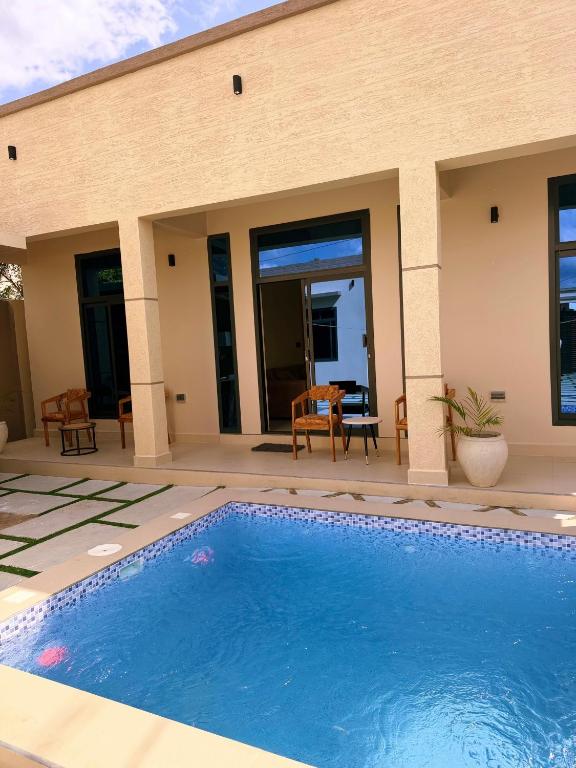 a swimming pool in front of a house at Cozynest nungwi in Nungwi