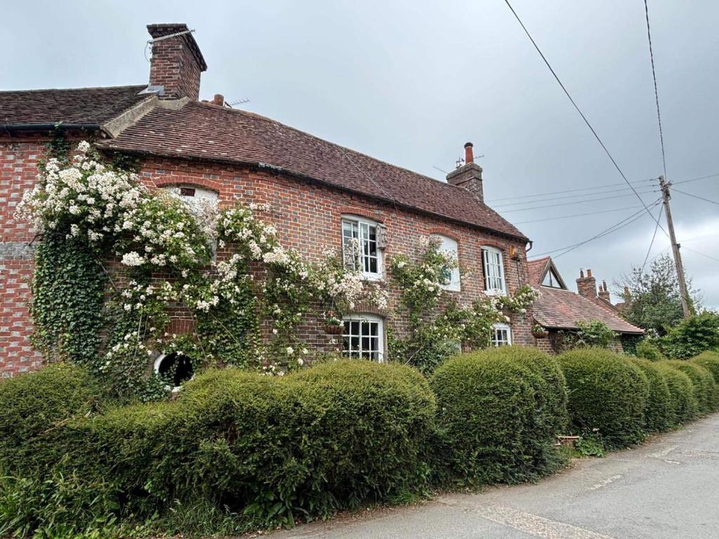an old brick house with white flowers on it at Sleeps 5 with in picturesque Chiddingly in Lewes