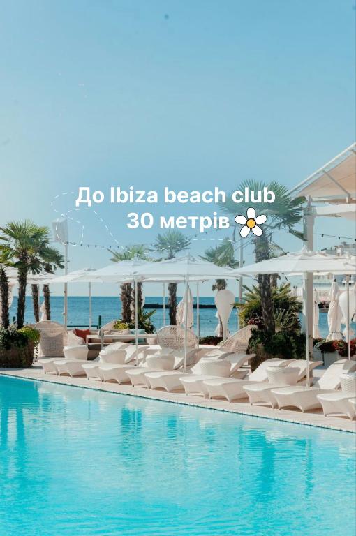 a swimming pool with a cruise ship in the background at Морський in Odesa