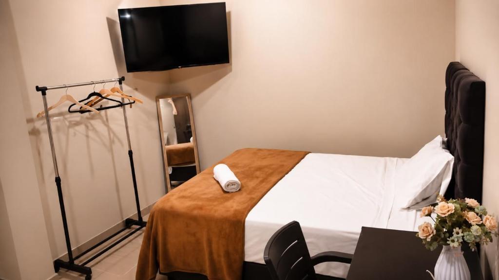 a room with a bed with a tv on the wall at HOTEL SAN GABRIEL cerca AL CENTRO DE CHICLAYO in Chiclayo
