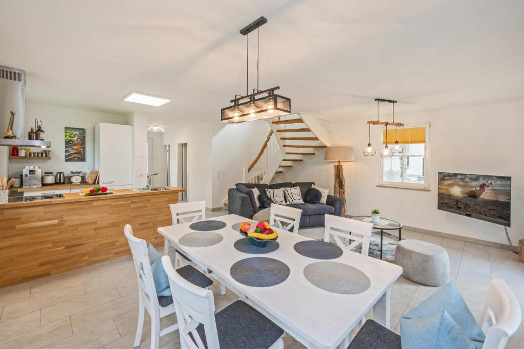 a dining room and living room with a table and chairs at Fischerdorf Ferienhaus JoHann in Zirchow