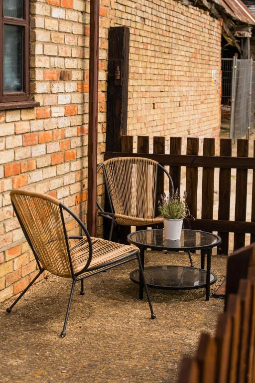 two chairs and a coffee table on a patio at Cottage 2 at Scald end cottages in Bedford