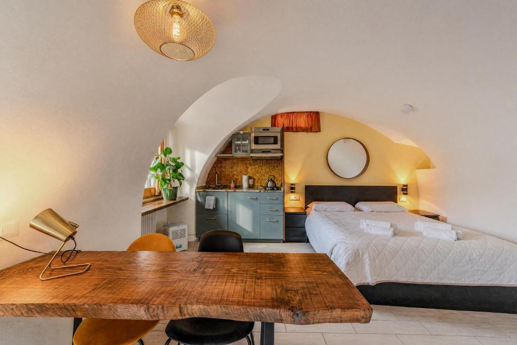 a bedroom with a bed and a table and a kitchen at Casa Anastasia with private patio by GardaDoma in Brenzone sul Garda