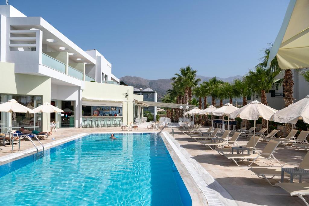 a pool at a hotel with chairs and umbrellas at Angela Suites Boutique Hotel in Sisi