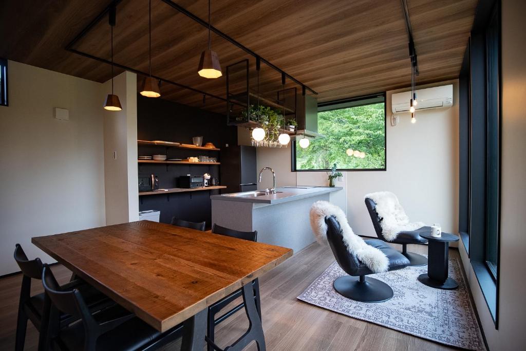 a kitchen and dining room with a wooden table and chairs at STARRY The Garden Hakuba Iwatake in Hakuba