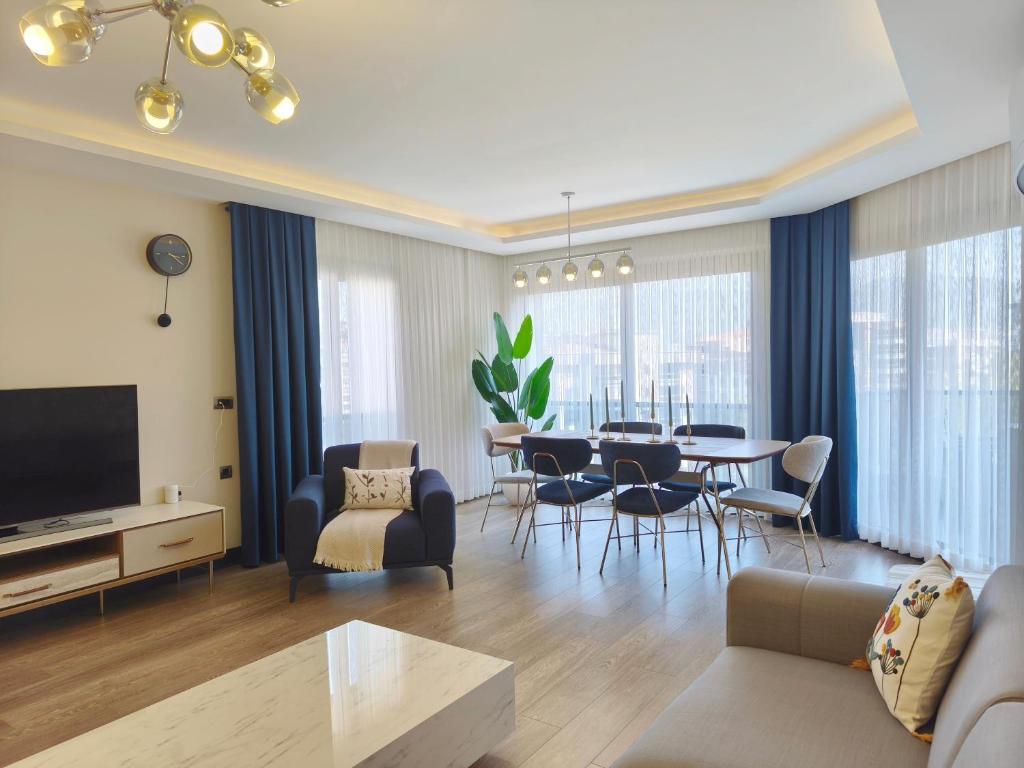a living room with a couch and a table at Utopia Suite Residence - 4 Bedroom Apartment in Burunabat