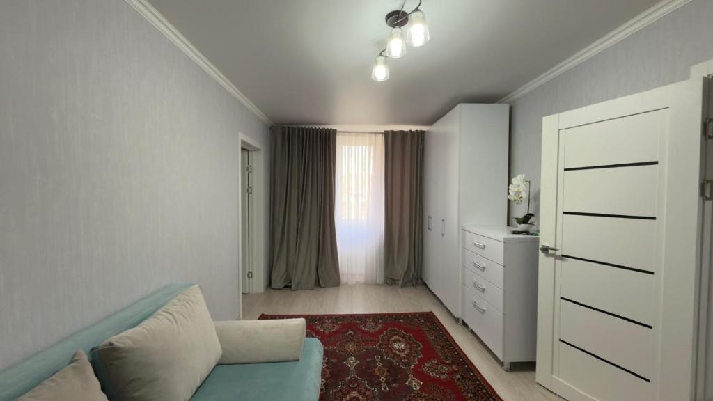 ein Wohnzimmer mit einer blauen Couch und einem Fenster in der Unterkunft The Pristine Elegance in Chişinău
