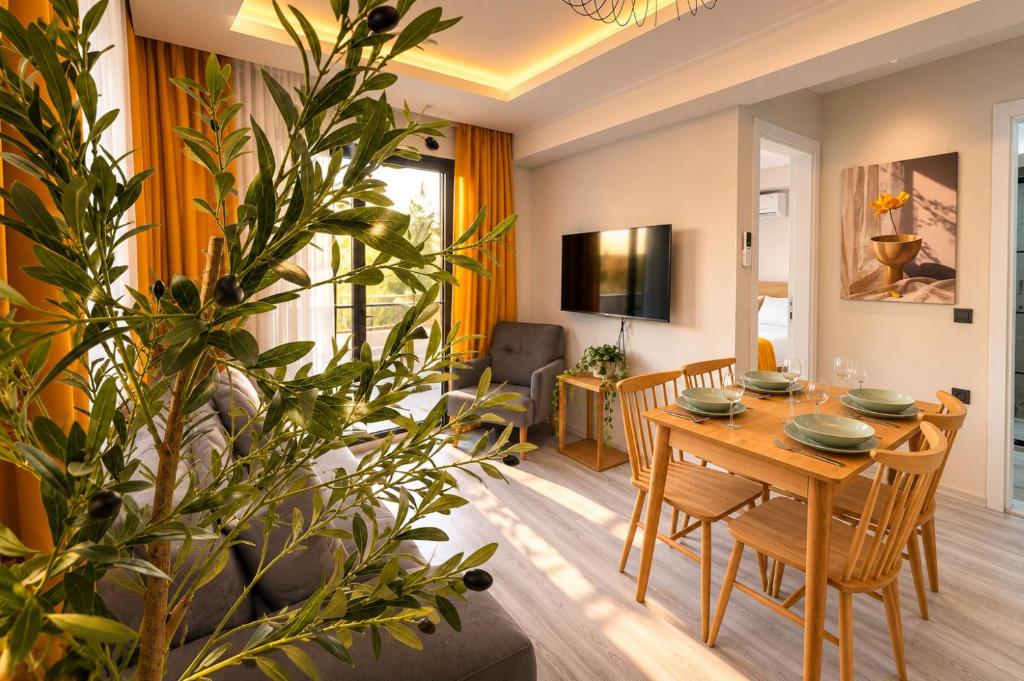 a dining room and living room with a table and a plant at Olivara Suites in Fethiye