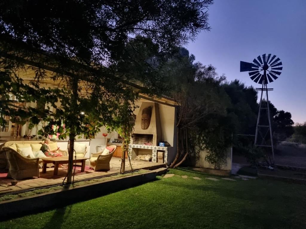 a farmhouse with a windmill in the yard at Konka Guest Farm in Carnarvon