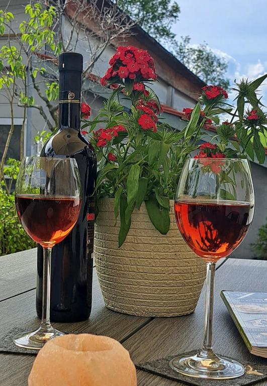 a bottle of wine and two glasses on a table at Eichkobel-Blick in Grünenbach