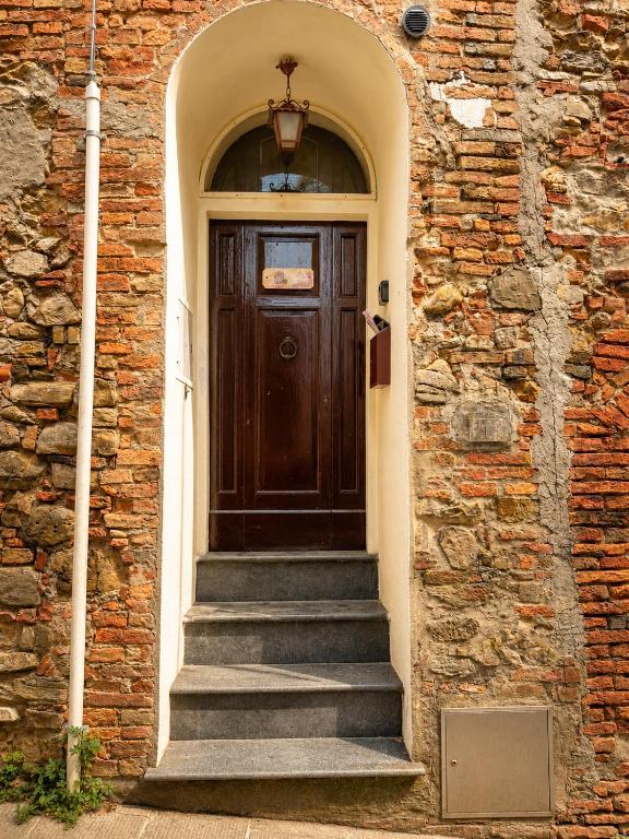 a wooden door with stairs in a brick building at La Piccola dimora in Gambassi Terme