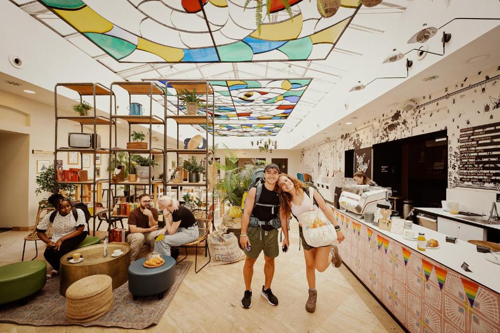a man and a woman walking through a store at Wombat's City Hostel Budapest in Budapest