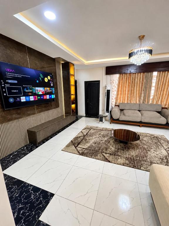 a living room with a couch and a tv at Jahi Luxe apartment in Gwarinpa