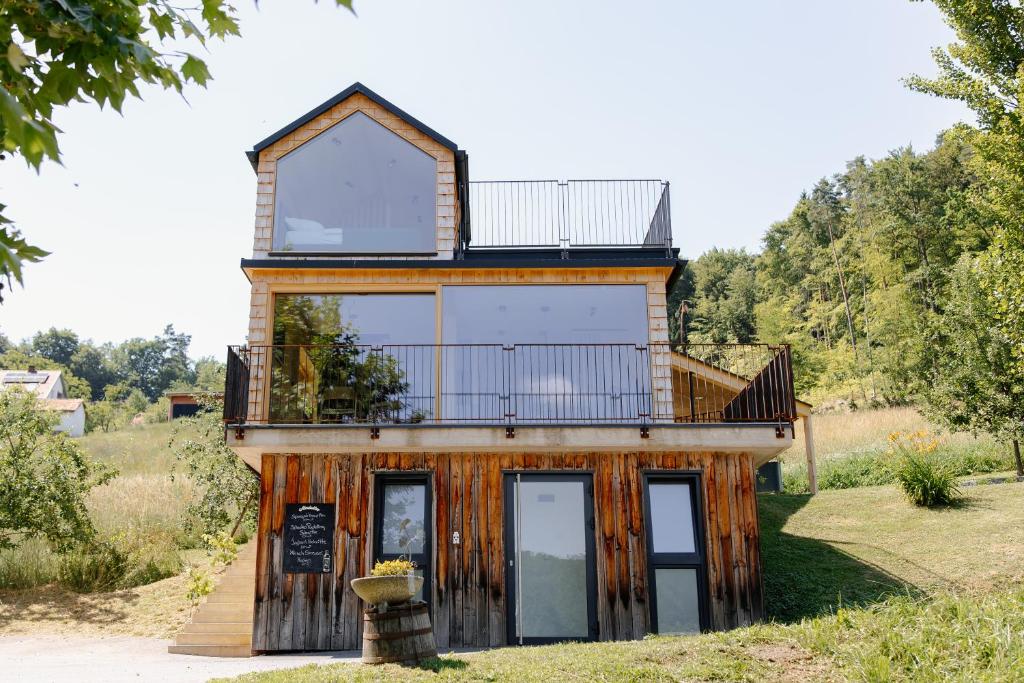 a house with a balcony on top of it at OFF Living Charlet in Pirching am Traubenberg