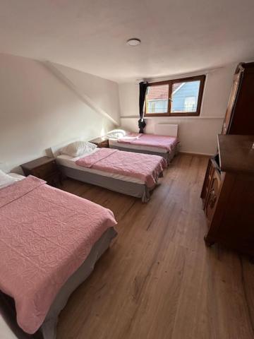 a room with three beds and a window at myappart - FORBACH in Forbach