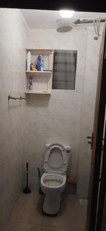 a bathroom with a toilet with the lid up at Urban Pulse Suites in Ruiru