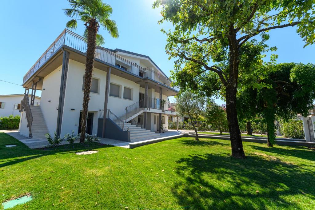 a house with a palm tree in the yard at Residence Da Marco in Pieve di Soligo