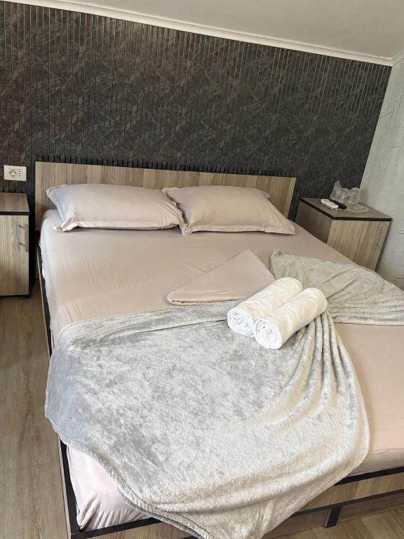 a bed with two rolled up towels on it at Amalya in Constanţa